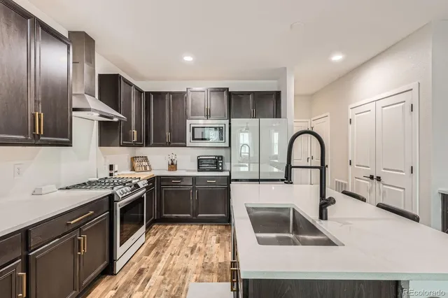 a kitchen with stainless steel appliances granite countertop a sink a stove and cabinets