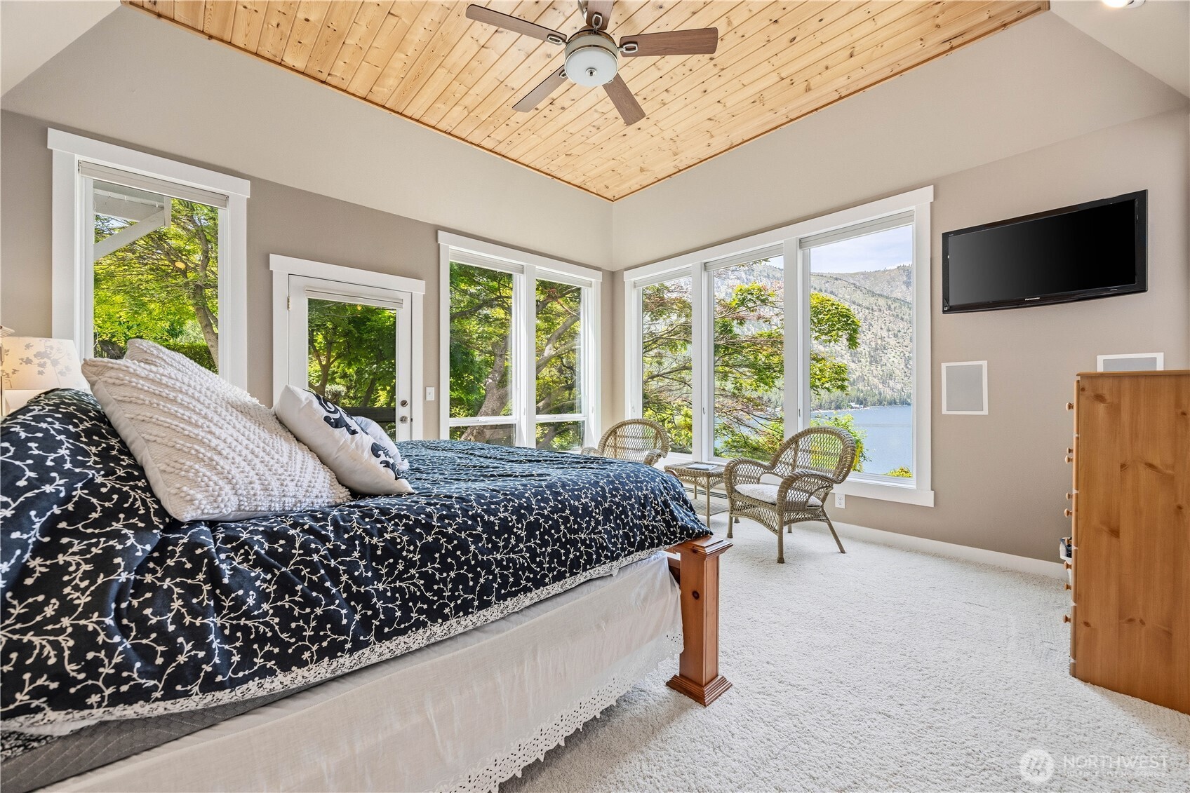 141 Sunset Place Manson, WA 98831 - Photo 14 of 38 a bed sitting in a bedroom next to a window with a flat screen tv
