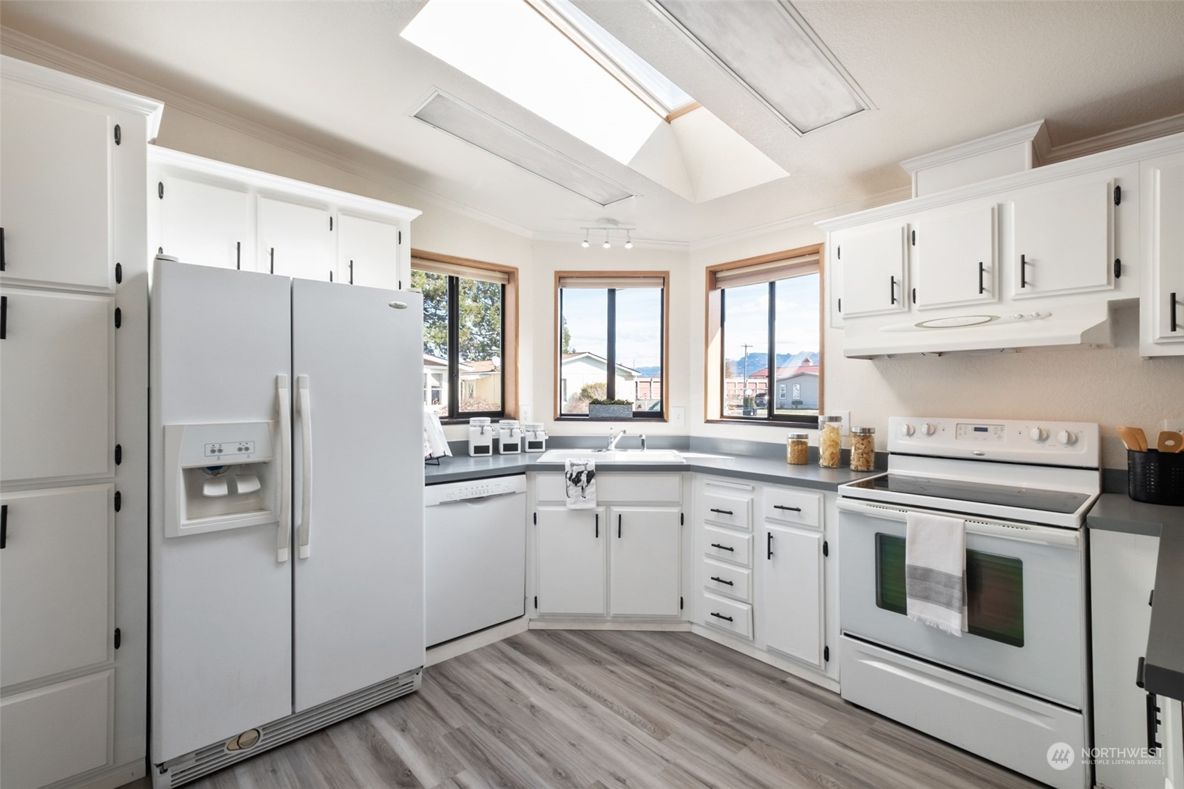 798 Pine Drive, Unit 798 Enumclaw, WA 98022 - Photo 11 of 20 a kitchen with cabinets appliances wooden floor and a window