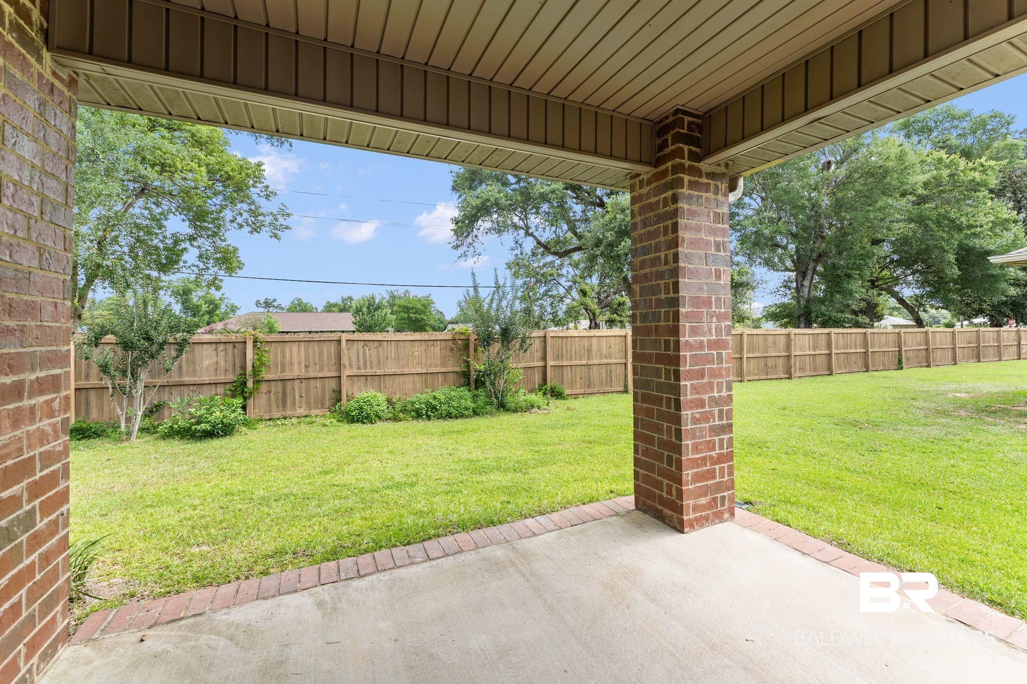 1464 Surrey Loop Foley, AL 36535 - Photo 4 of 24 Fenced backyard featuring a patio
