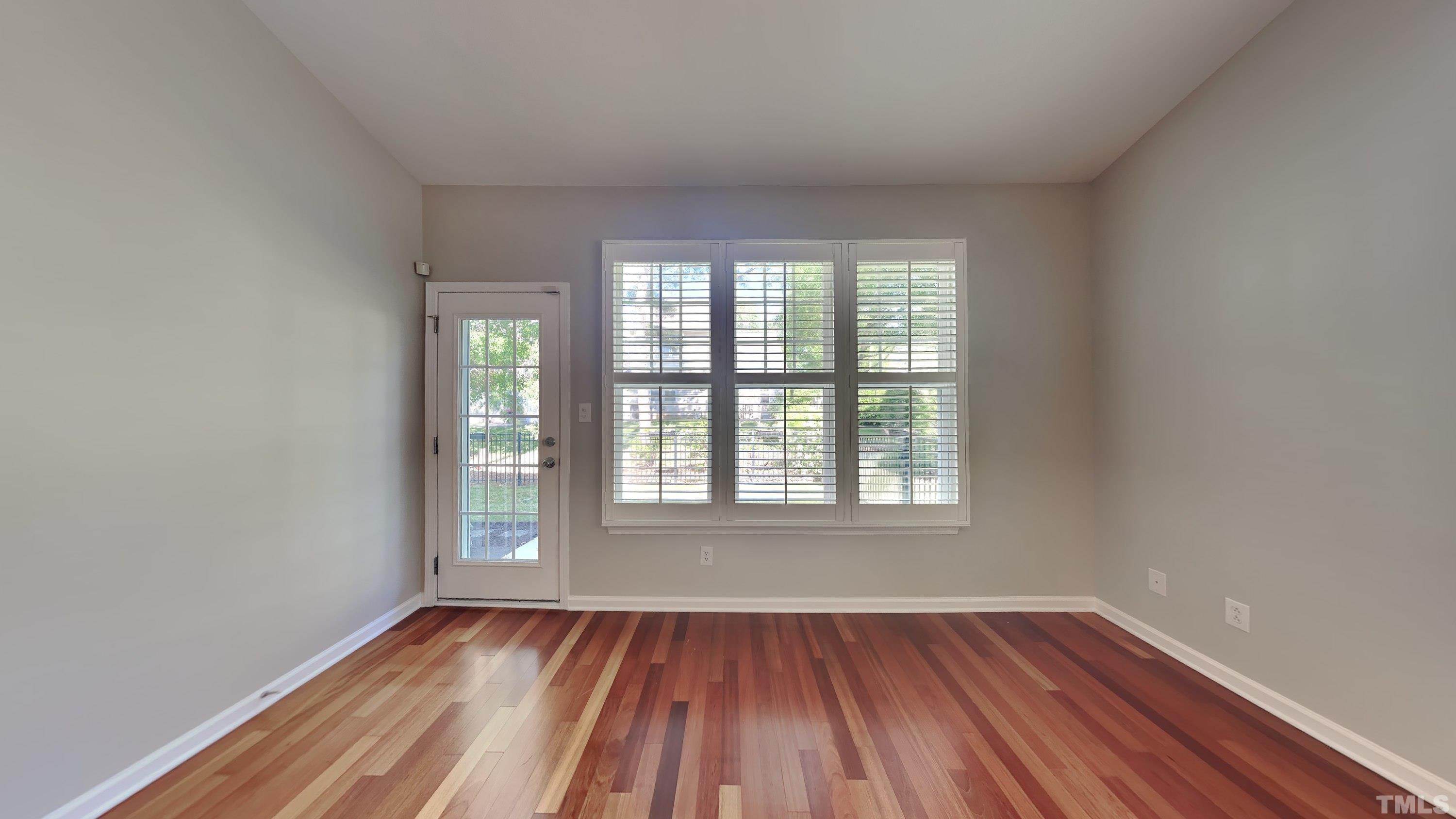 2 Water Garden Way Durham, NC 27713 - Photo 3 of 16 an empty room with wooden floor and windows