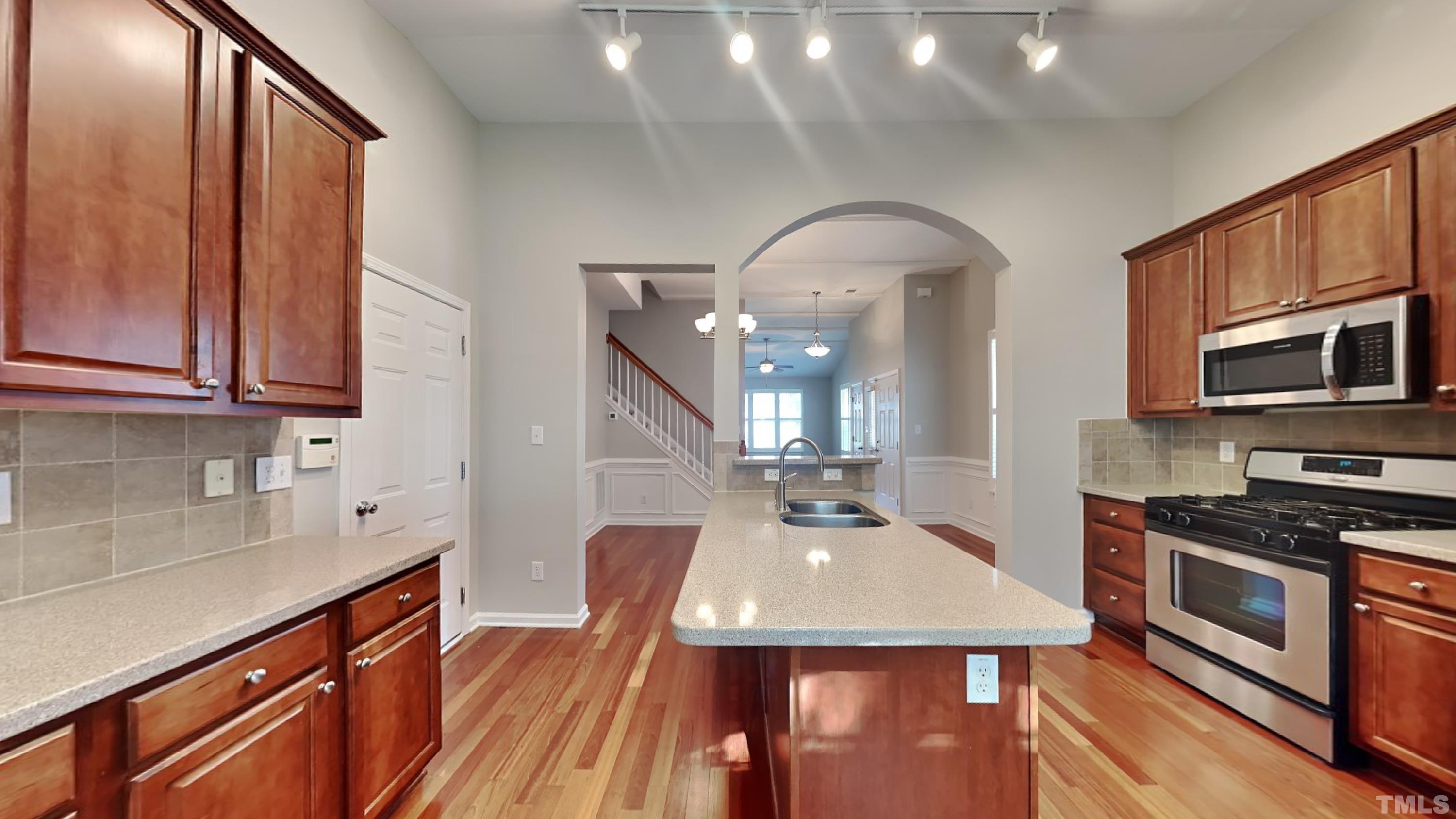 2 Water Garden Way Durham, NC 27713 - Photo 5 of 16 a kitchen with stainless steel appliances wooden floor dining table and chairs