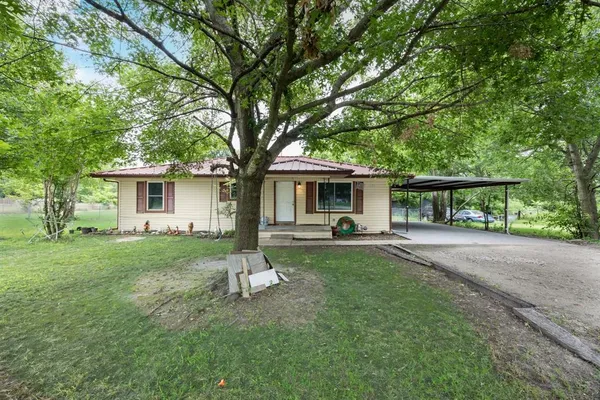 a view of a house with backyard and a tree