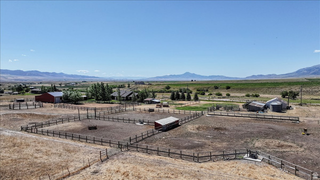 1634 West Arimo Road Arimo, ID 83214 - Photo 79 of 89 Expansive agricultural property featuring multiple fenced paddocks, a red barn with a metal roof, and additional outbuildings
