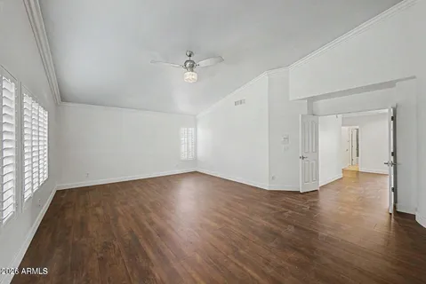 an empty room with wooden floor and windows