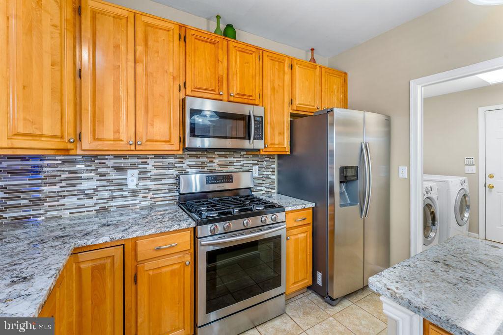 14701 Danton Court Bowie, MD 20721 - Photo 18 of 60 a kitchen with stainless steel appliances granite countertop a stove a refrigerator and a sink
