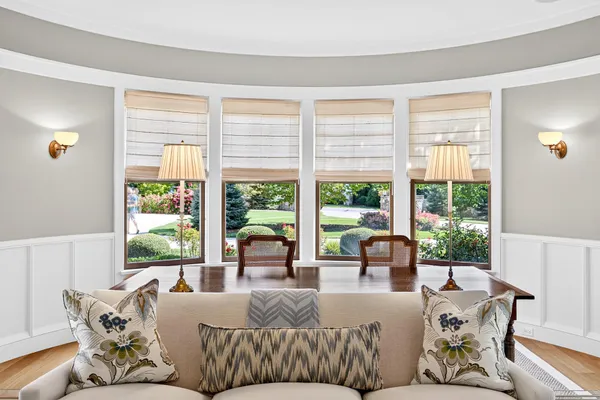 a bedroom with a large bed and a lamp on dresser