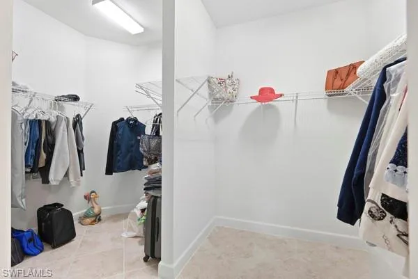 a view of walk in closet with clothes and shoes