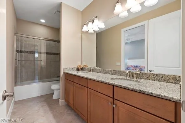a bathroom with a granite countertop sink a toilet and shower