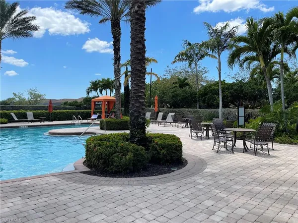 a view of a swimming pool with tables and chairs
