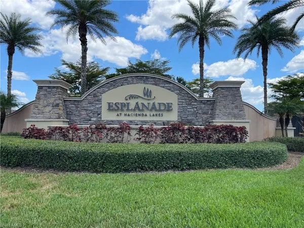 a front view of multi story residential apartment building with yard and green space
