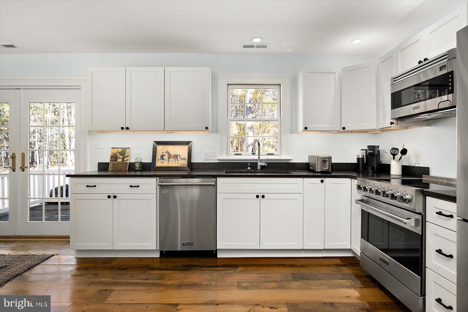 964 Taylors Island Road Madison, MD 21648 - Photo 80 of 106 a kitchen with stainless steel appliances granite countertop a stove a sink and white cabinets