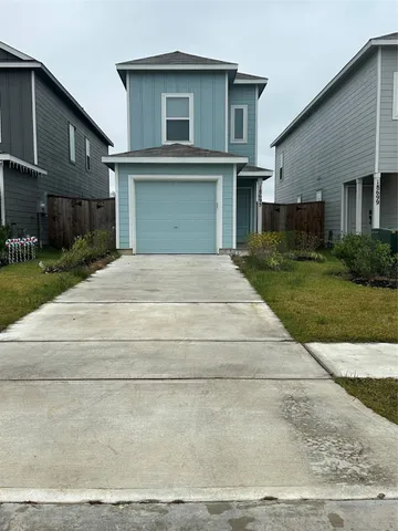 a front view of a house with a garden and garage
