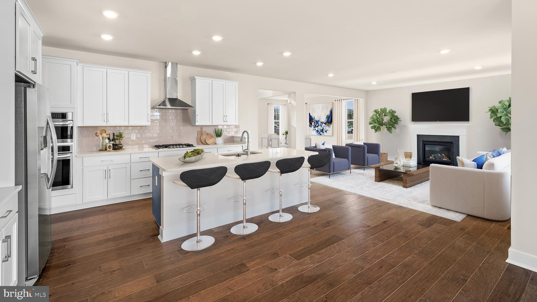 a large white kitchen with cabinets and chairs