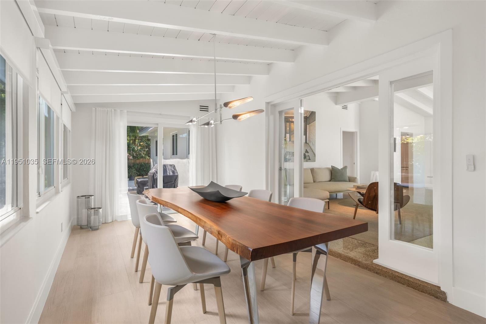 1040 Northeast 85th Street Miami, FL 33138 - Photo 12 of 22 a view of a dining room and livingroom with furniture wooden floor a chandelier