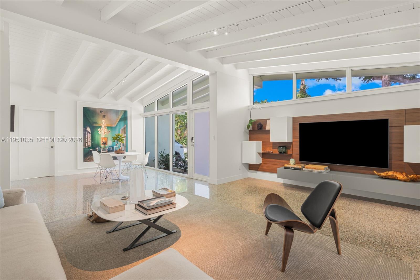 1040 Northeast 85th Street Miami, FL 33138 - Photo 5 of 22 a living room with furniture a flat screen tv and a fireplace