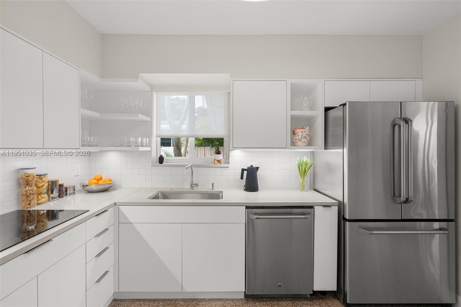 1040 Northeast 85th Street Miami, FL 33138 - Photo 10 of 22 a kitchen with refrigerator a sink a stove a microwave and cabinets