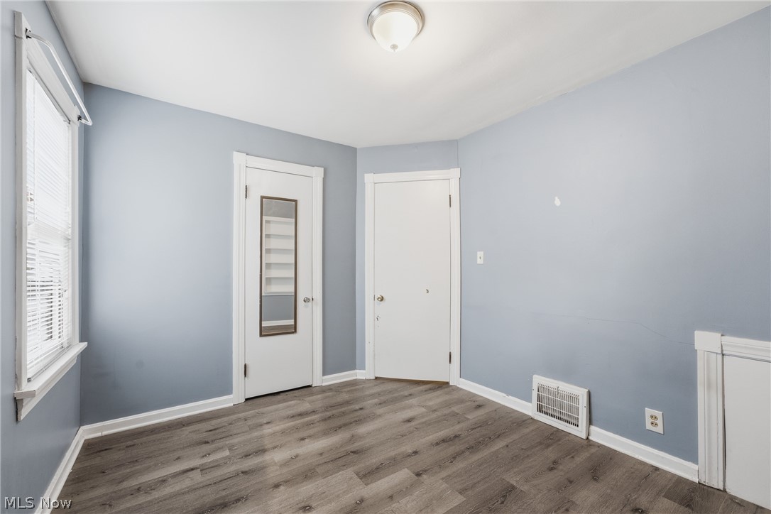 311 Fowles Road Berea, OH 44017 - Photo 18 of 40 Interior space featuring wood-finish flooring, two white panel doors, and a window with blinds