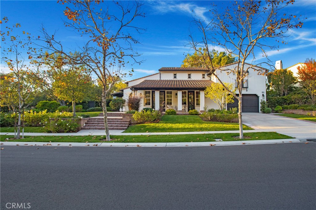 a front view of a house with a yard and fountain in middle