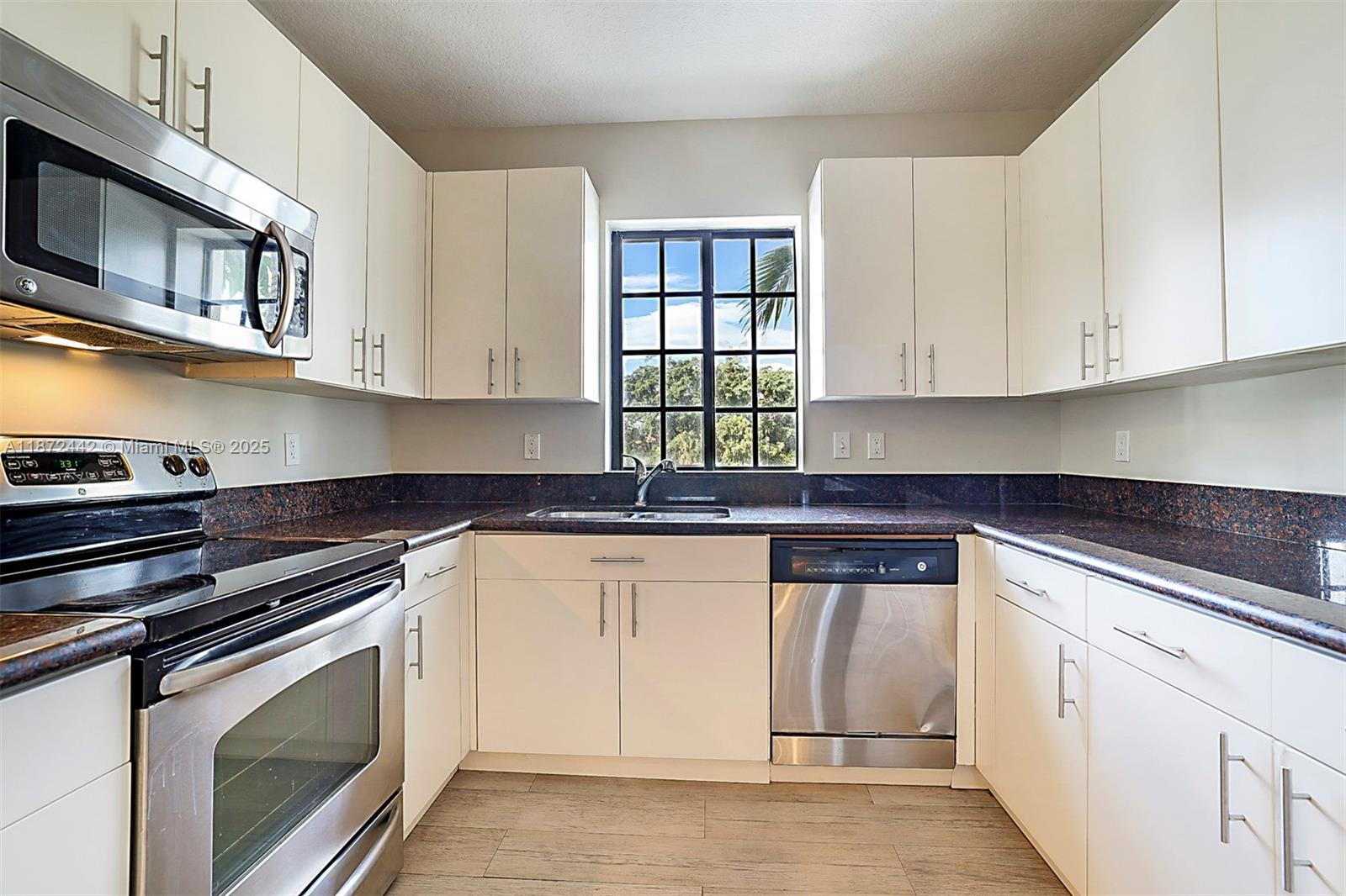 4905 Midtown Lane, Unit 2209 Palm Beach Gardens, FL 33418 - Photo 11 of 30 a kitchen with stainless steel appliances granite countertop a stove and cabinets