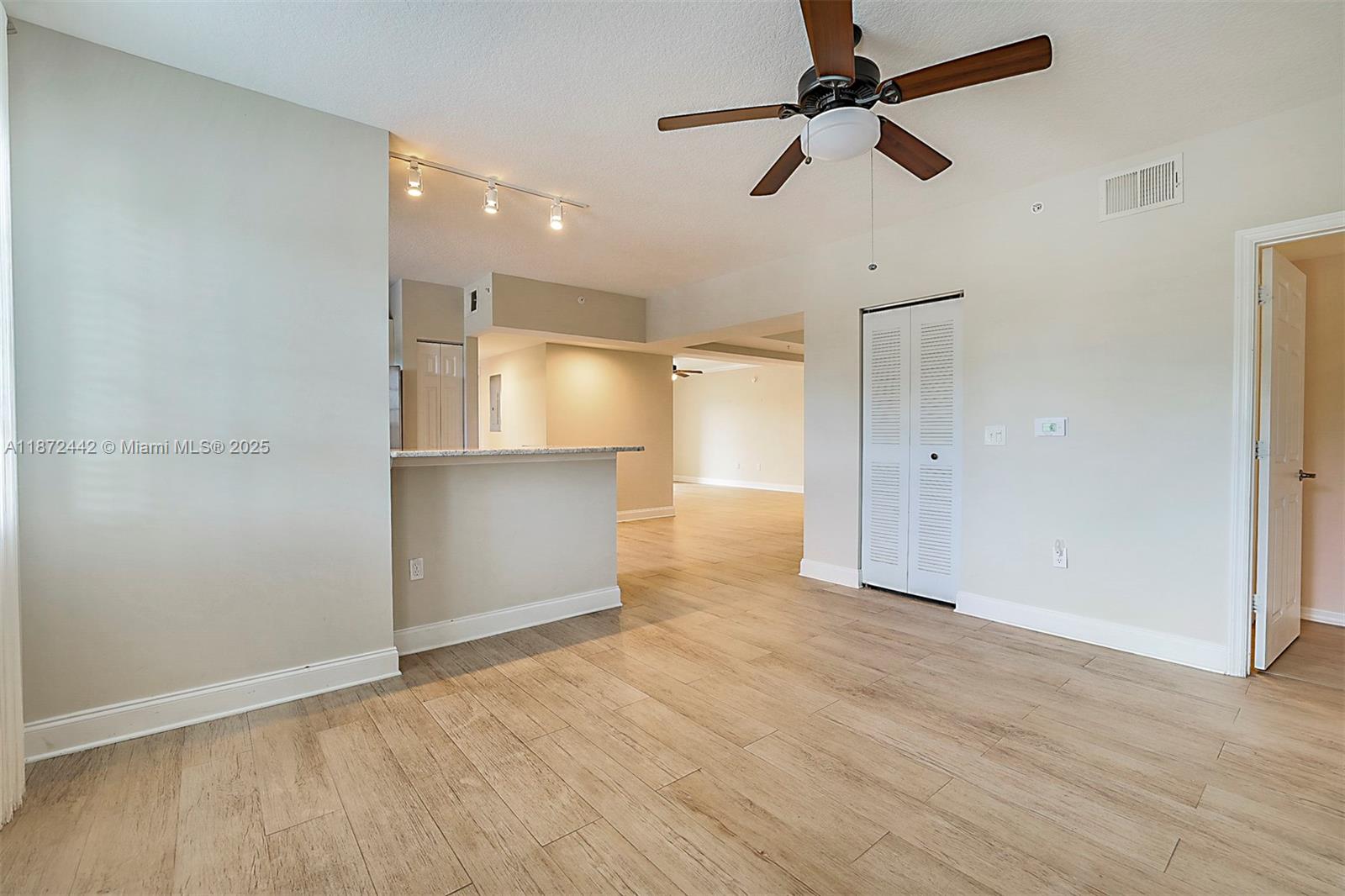 4905 Midtown Lane, Unit 2209 Palm Beach Gardens, FL 33418 - Photo 13 of 30 wooden floor in an empty room with a kitchen