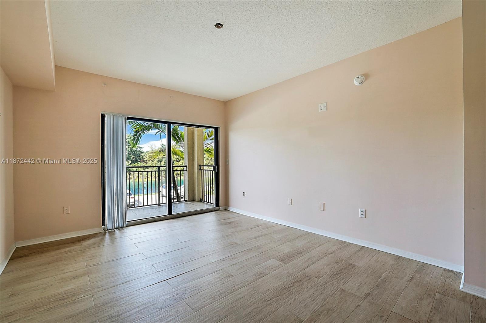 4905 Midtown Lane, Unit 2209 Palm Beach Gardens, FL 33418 - Photo 16 of 30 a view of an empty room with wooden floor and a window