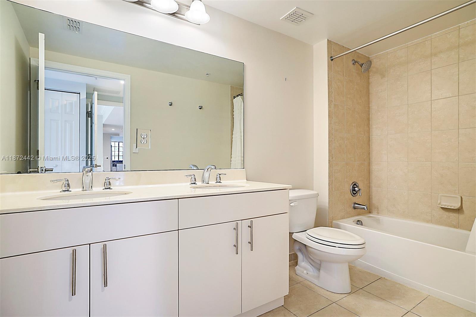 4905 Midtown Lane, Unit 2209 Palm Beach Gardens, FL 33418 - Photo 25 of 30 a bathroom with a double vanity sink toilet mirror and shower