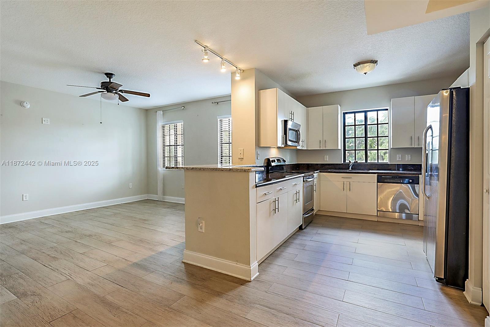 4905 Midtown Lane, Unit 2209 Palm Beach Gardens, FL 33418 - Photo 9 of 30 a kitchen with granite countertop a stove cabinets and a refrigerator