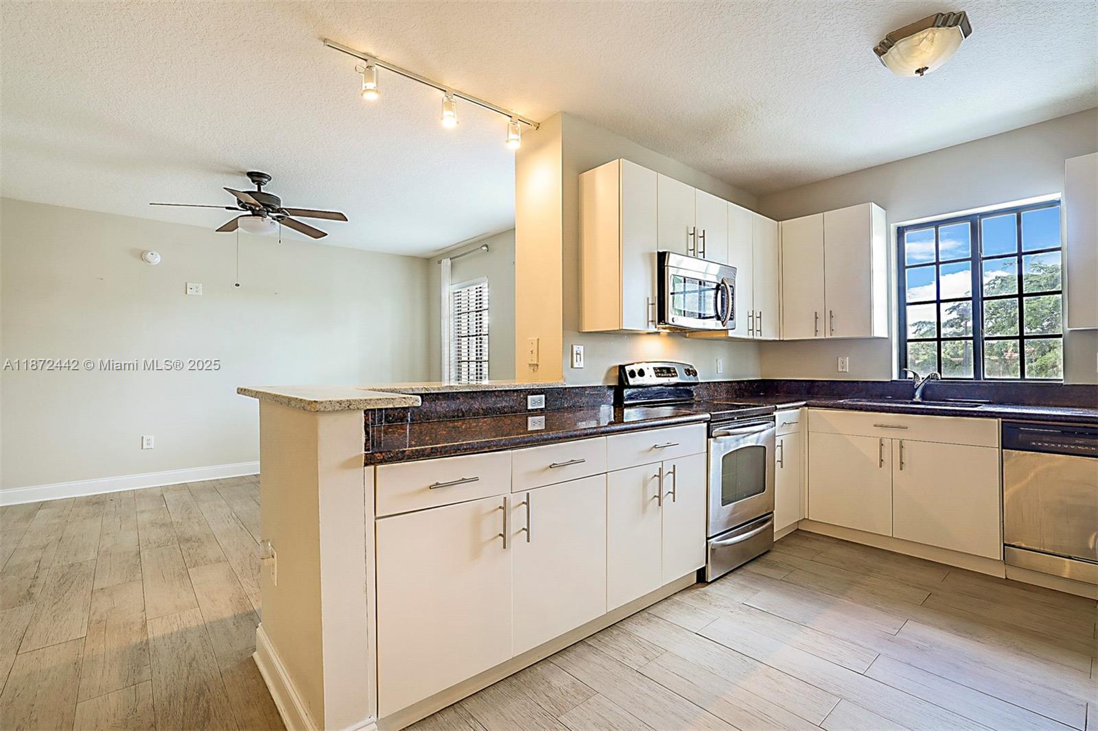 4905 Midtown Lane, Unit 2209 Palm Beach Gardens, FL 33418 - Photo 10 of 30 a kitchen with granite countertop white cabinets white appliances with a sink and dishwasher