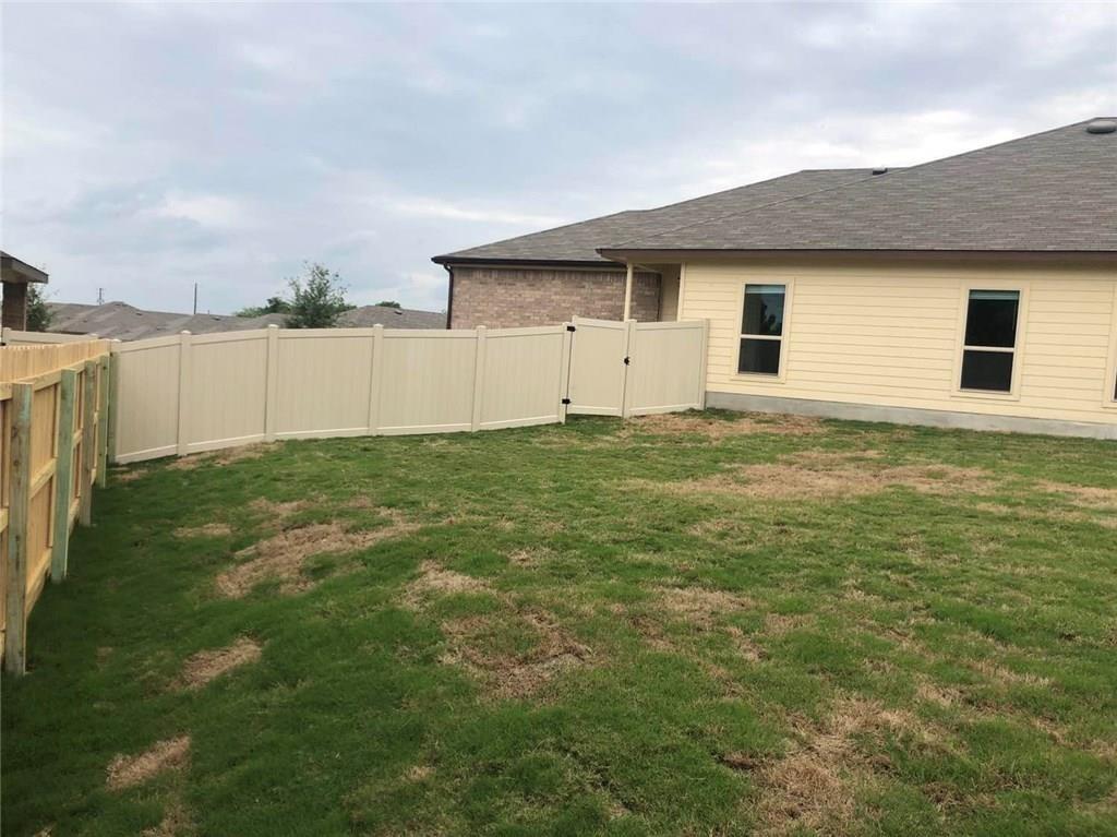 351 Joanne Loop, Unit A Buda, TX 78610 - Photo 15 of 17 A well-maintained yard, fully fenced for privacy, offers ample space for outdoor enjoyment.