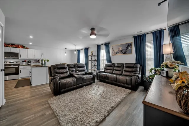 a living room with furniture and kitchen view
