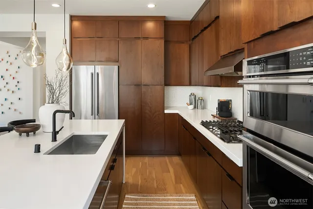 a kitchen with stainless steel appliances a sink stove and refrigerator