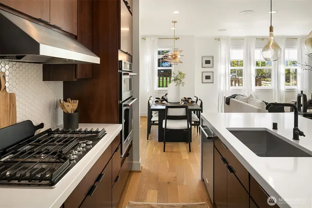 a kitchen with stainless steel appliances granite countertop a sink stove and refrigerator