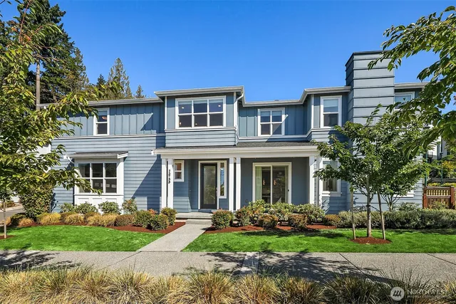 a front view of a house with garden and trees