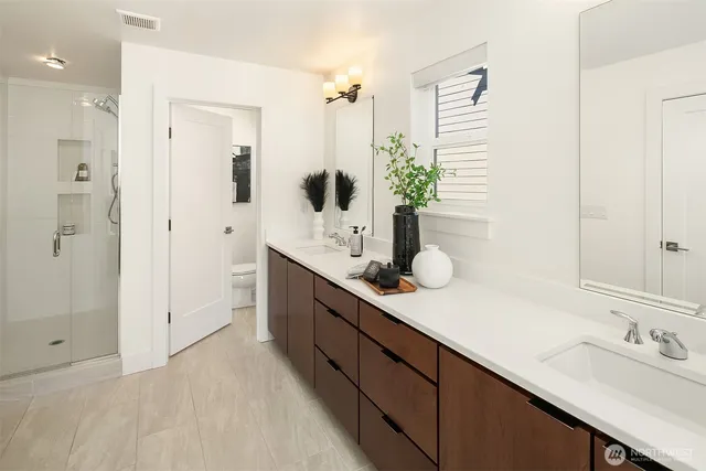 a bathroom with a double vanity sink and mirror