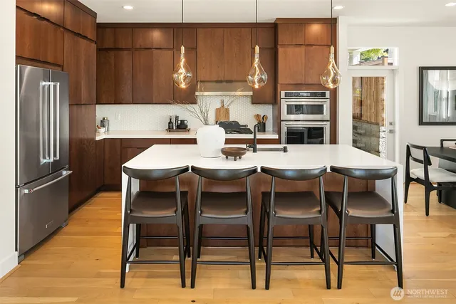 a kitchen with a dining table chairs and refrigerator