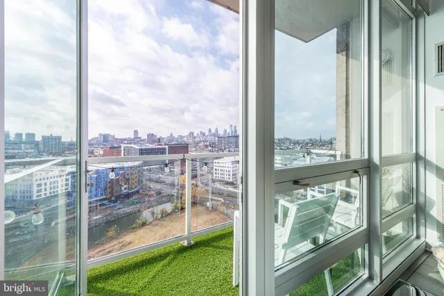 a view of a glass door and porch next to a yard