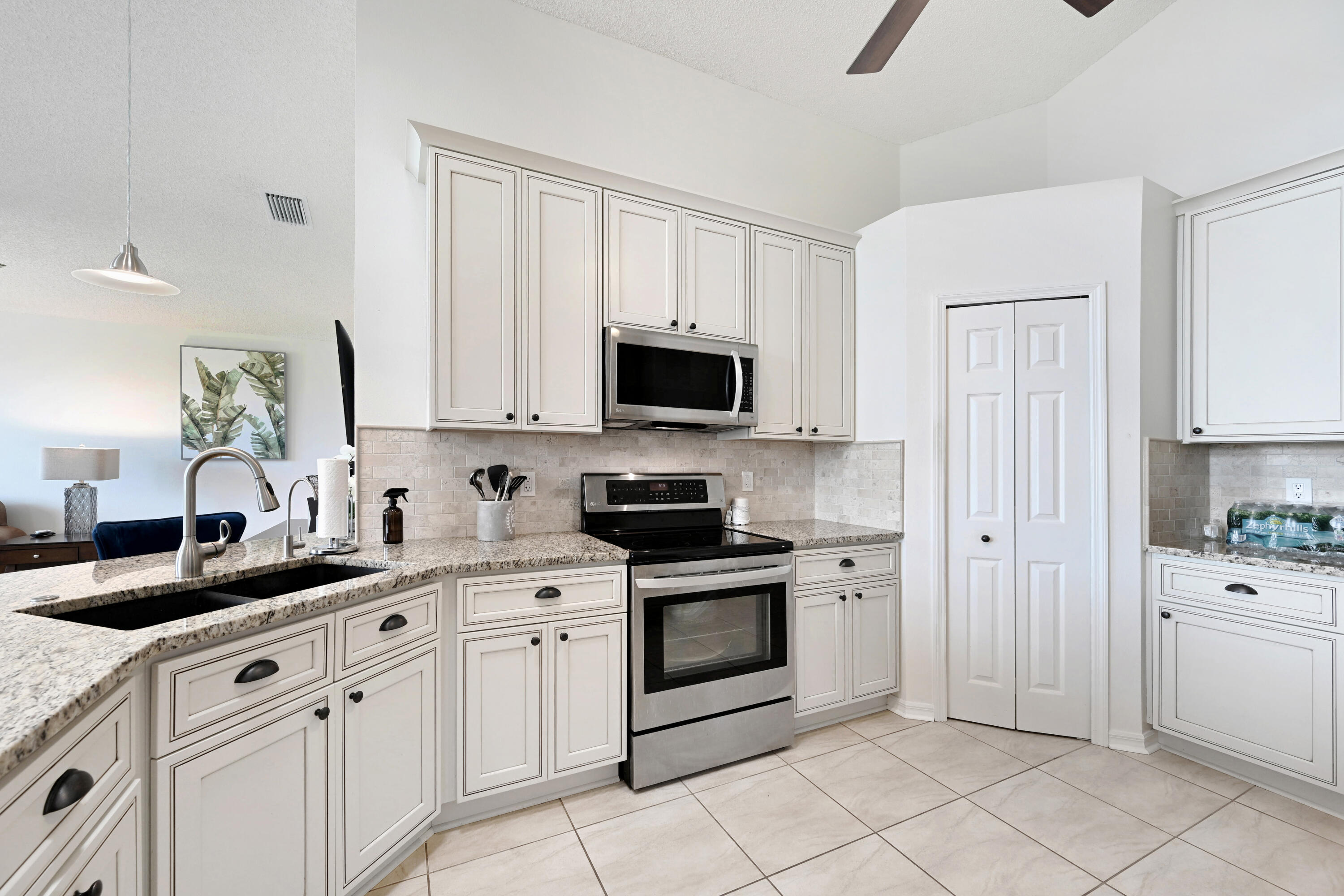 897 Shaw Circle Melbourne, FL 32940 - Photo 31 of 57 a kitchen with white cabinets and appliances