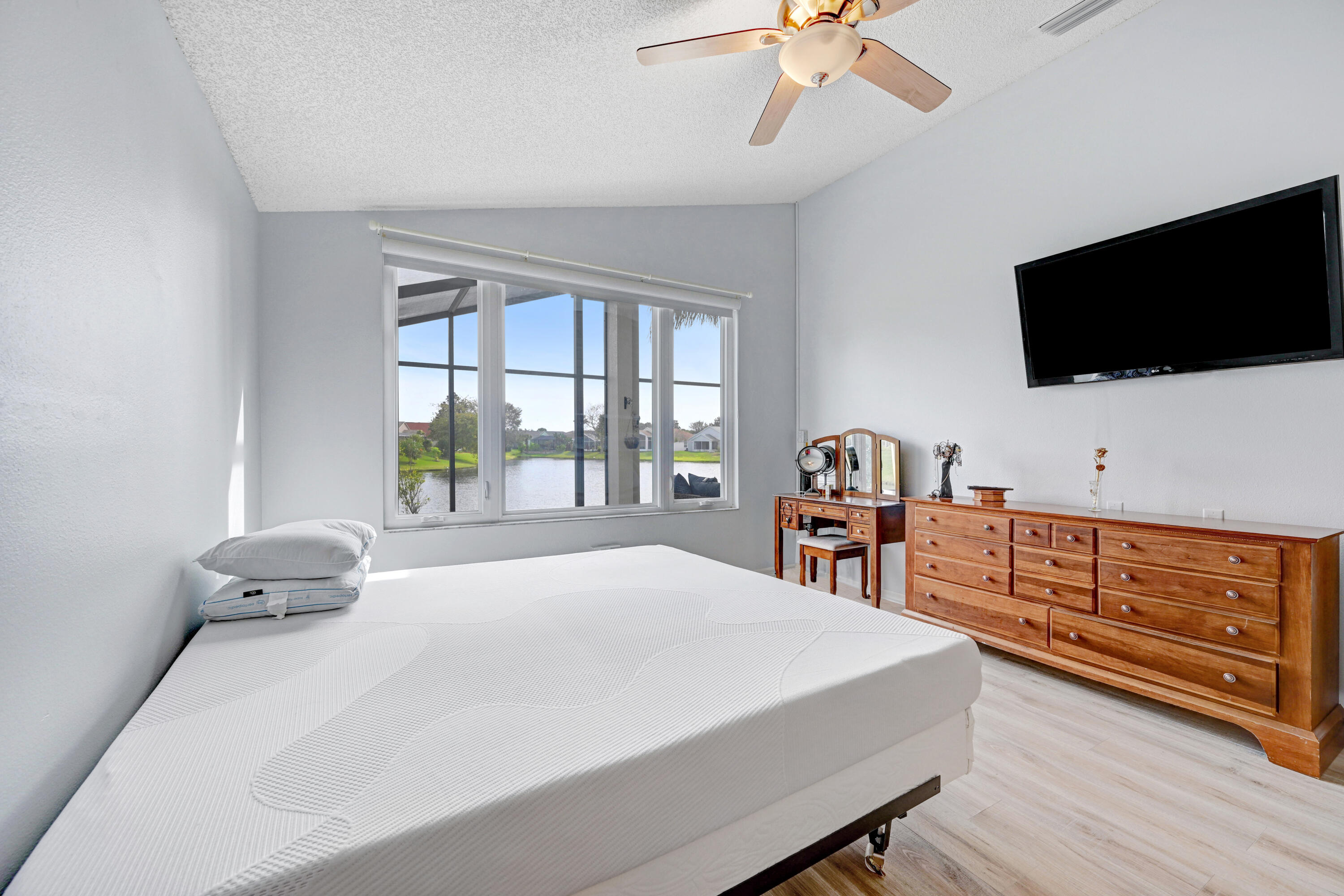 897 Shaw Circle Melbourne, FL 32940 - Photo 54 of 57 a bedroom with a bed and a flat tv screen on dresser