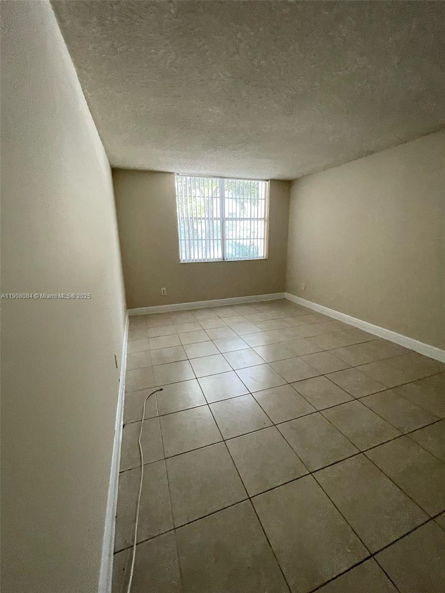 486 Northwest 165th Street, Unit B108 Miami, FL 33169 - Photo 4 of 8 a view of an empty room and a window