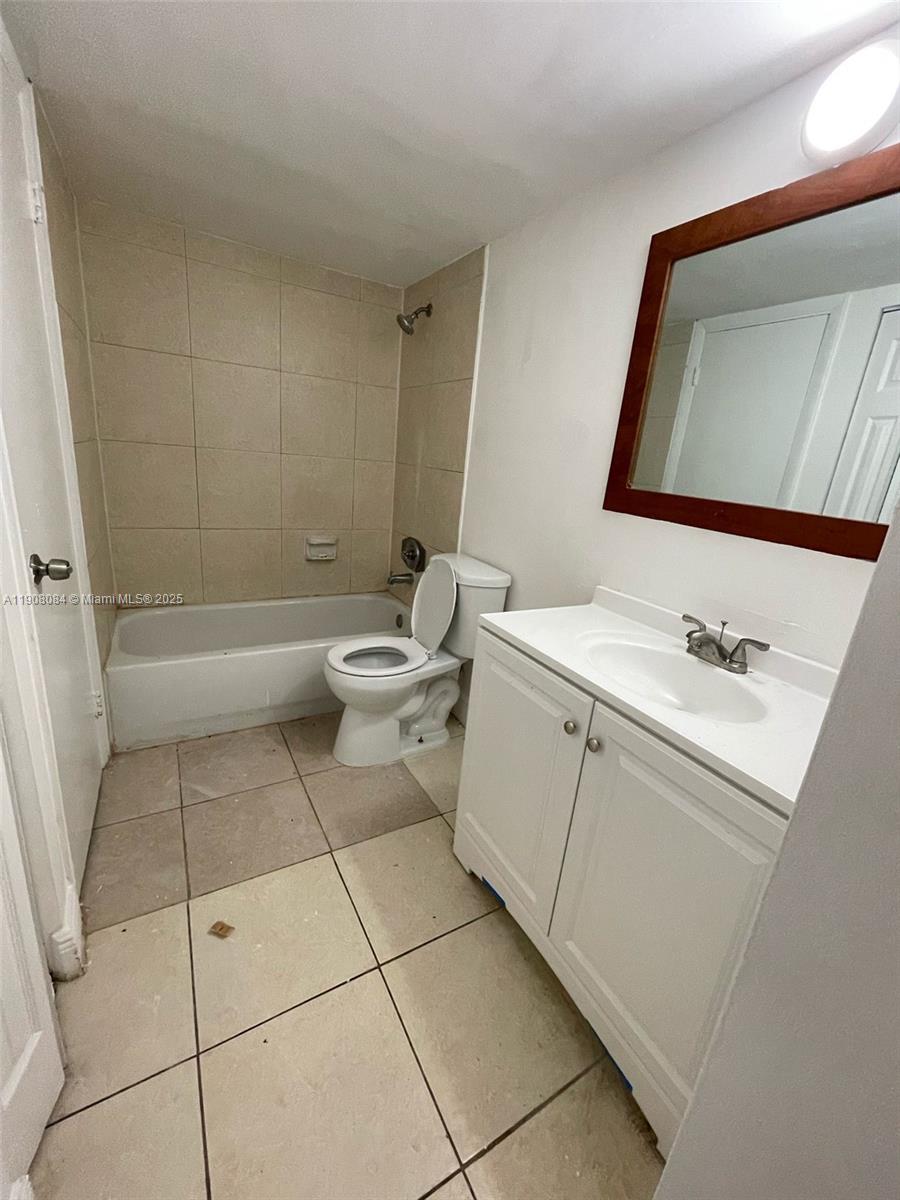 486 Northwest 165th Street, Unit B108 Miami, FL 33169 - Photo 6 of 8 a bathroom with a toilet sink and mirror