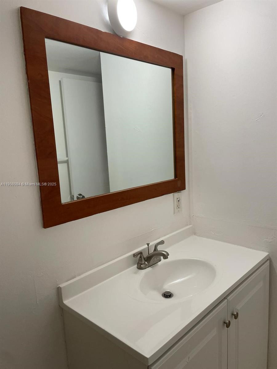 486 Northwest 165th Street, Unit B108 Miami, FL 33169 - Photo 7 of 8 a bathroom with a sink and a mirror