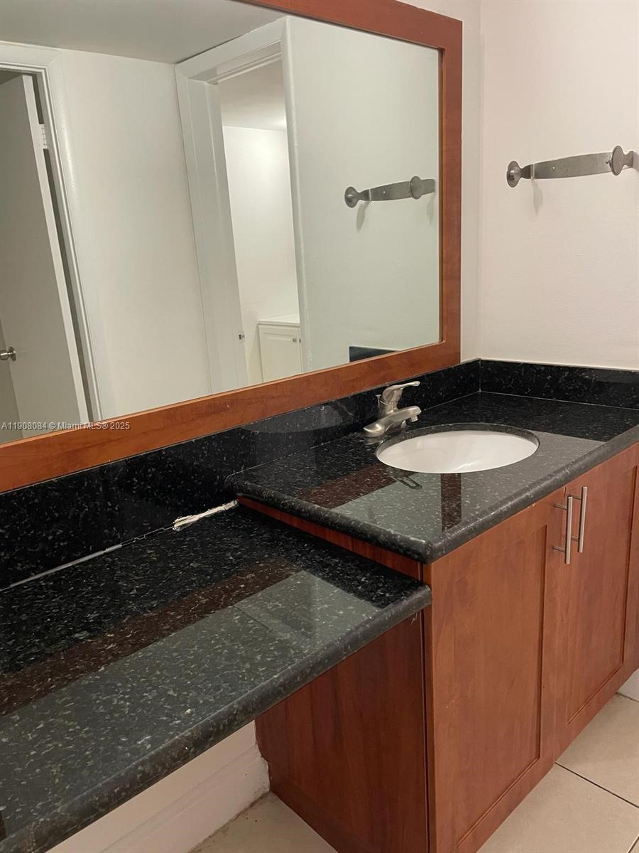 486 Northwest 165th Street, Unit B108 Miami, FL 33169 - Photo 8 of 8 a bathroom with a sink and a mirror
