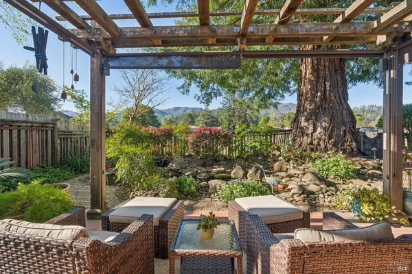 a view of a patio with table and chairs potted plants with wooden floor and fence