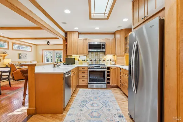 a kitchen with stainless steel appliances granite countertop a stove a sink and a microwave