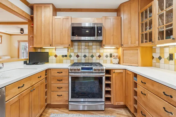 a kitchen with stainless steel appliances granite countertop a sink and a stove top oven