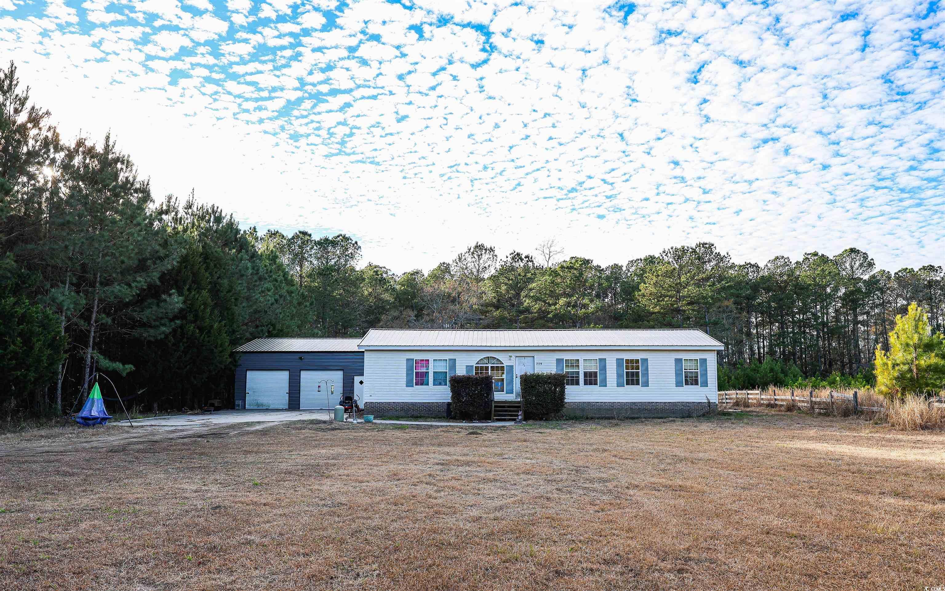 2128 Harvey Road Loris, SC 29569 - Photo 1 of 31 View of front facade with a metal roof, a front lawn, and a view of trees