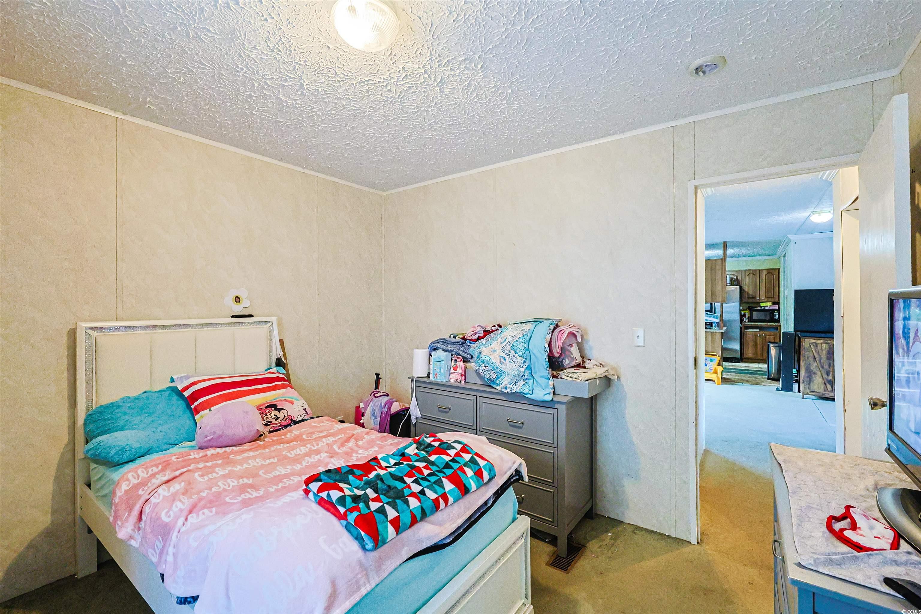 2128 Harvey Road Loris, SC 29569 - Photo 11 of 31 Bedroom featuring a textured ceiling, carpet, and freestanding refrigerator
