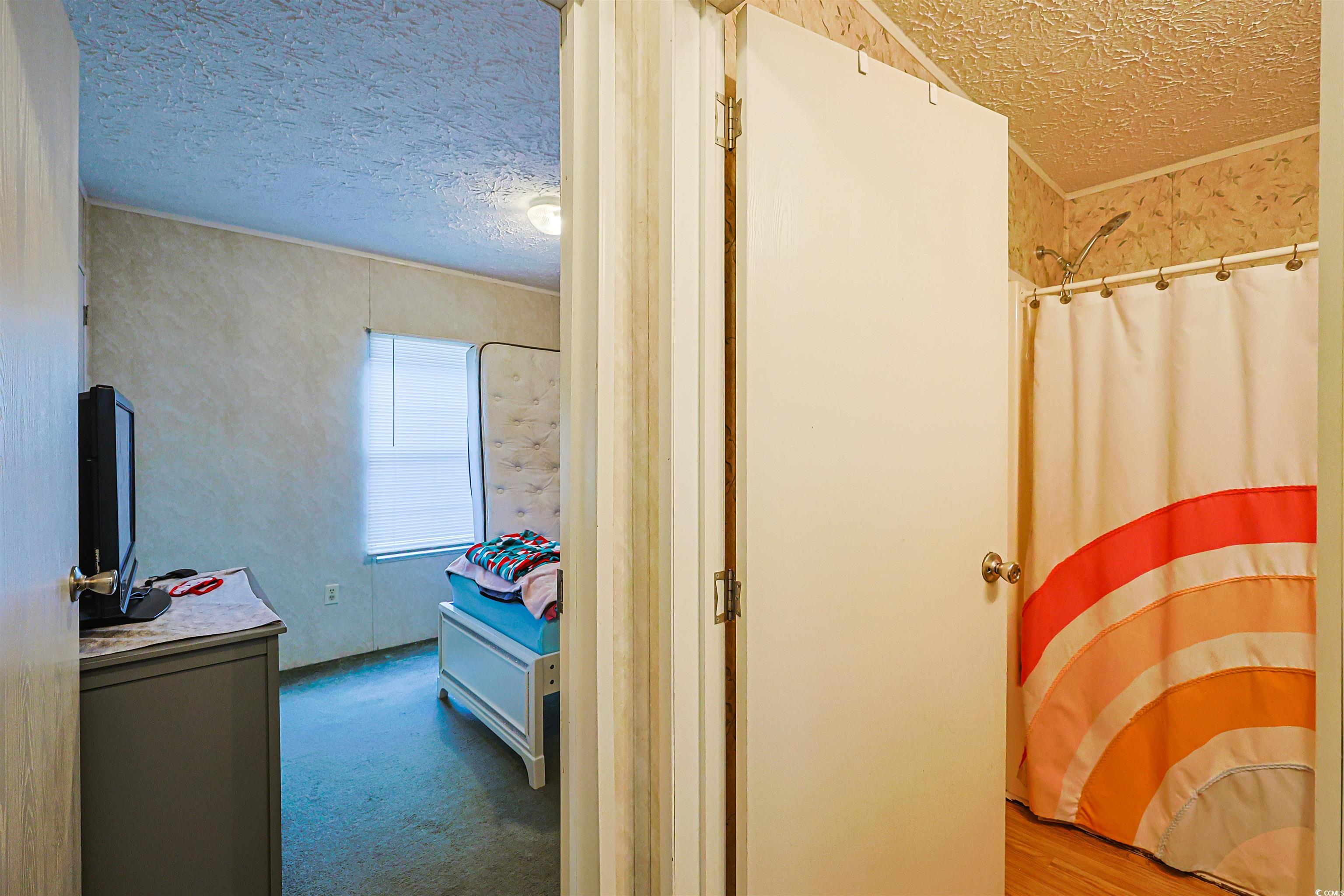 2128 Harvey Road Loris, SC 29569 - Photo 13 of 31 Bathroom featuring a textured ceiling, curtained shower, and carpet flooring