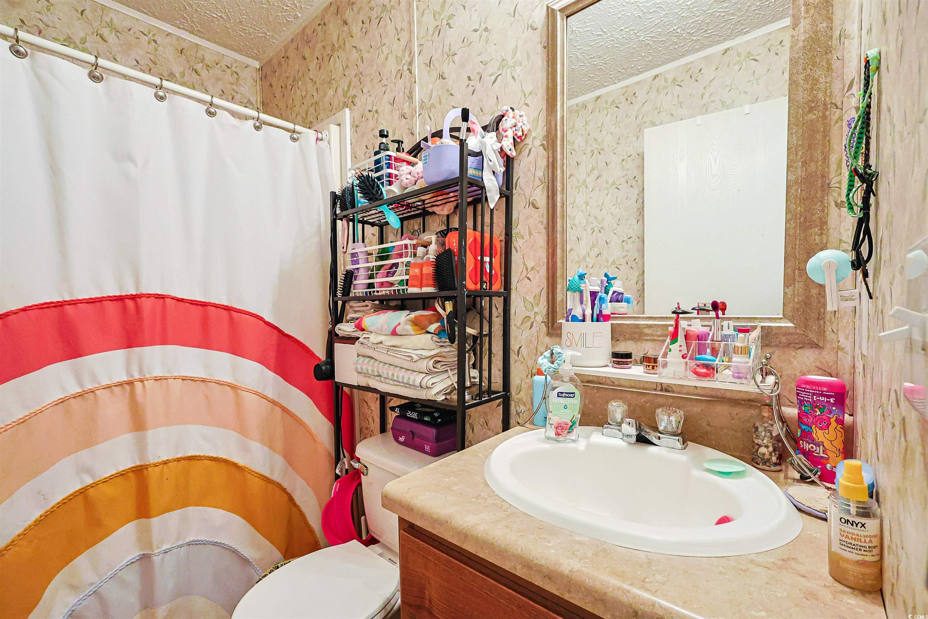 2128 Harvey Road Loris, SC 29569 - Photo 14 of 31 Bathroom with curtained shower, wallpapered walls, vanity, and a textured ceiling